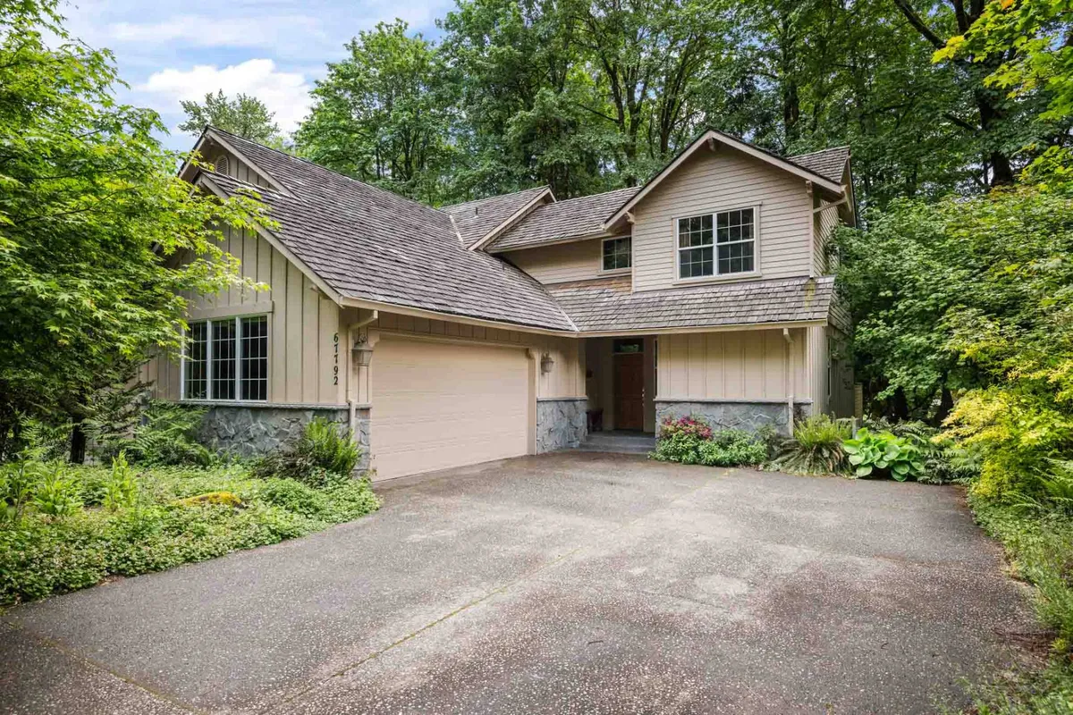 This exterior shot showcases the front of the home, including the inviting front door, the garage, and well-maintained landscaping. The setting hints at proximity to peaceful surroundings and outdoor activities, with mature trees that could be part of the fragrant pines mentioned.