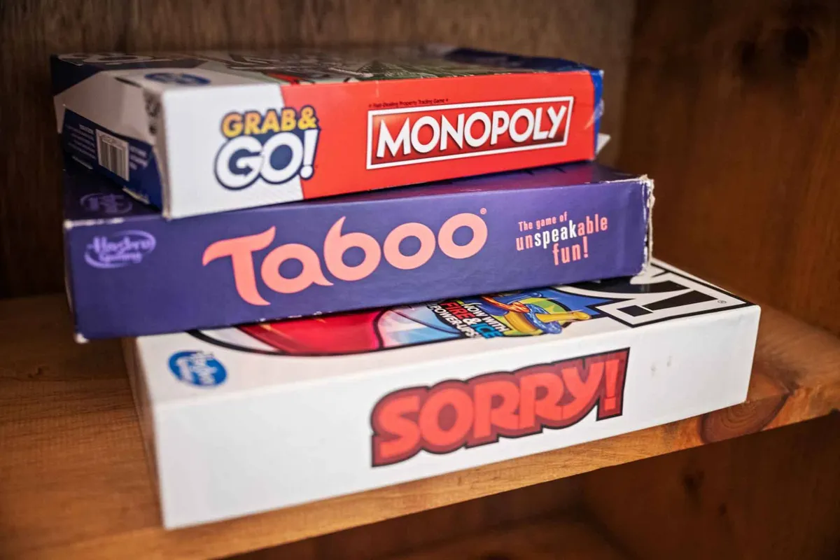 A selection of classic board games, including Monopoly, Taboo, and Sorry!, laid out and ready for play. The cheerful mood suggests interactive evenings spent bonding over friendly competition.
