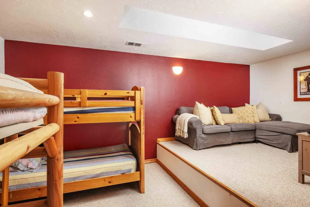 A spacious bonus room with bunk beds, a comfortable sofa, and vibrant throw pillows. This area is ideal for group slumber parties, game nights, or extra sleeping space for guests, delivering both comfort and flexibility.